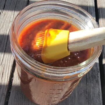 jar of barbecue sauce with grill brush