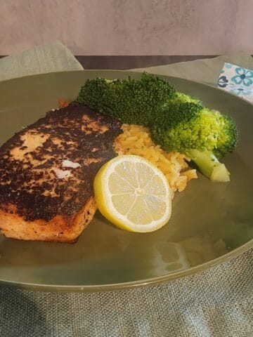plated salmon, with rice, broccoli, and lemon slice garnish
