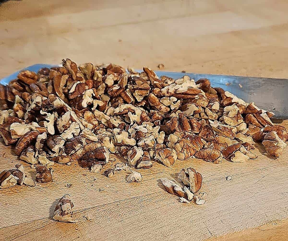 chopped pecans on a cutting board with a knife
