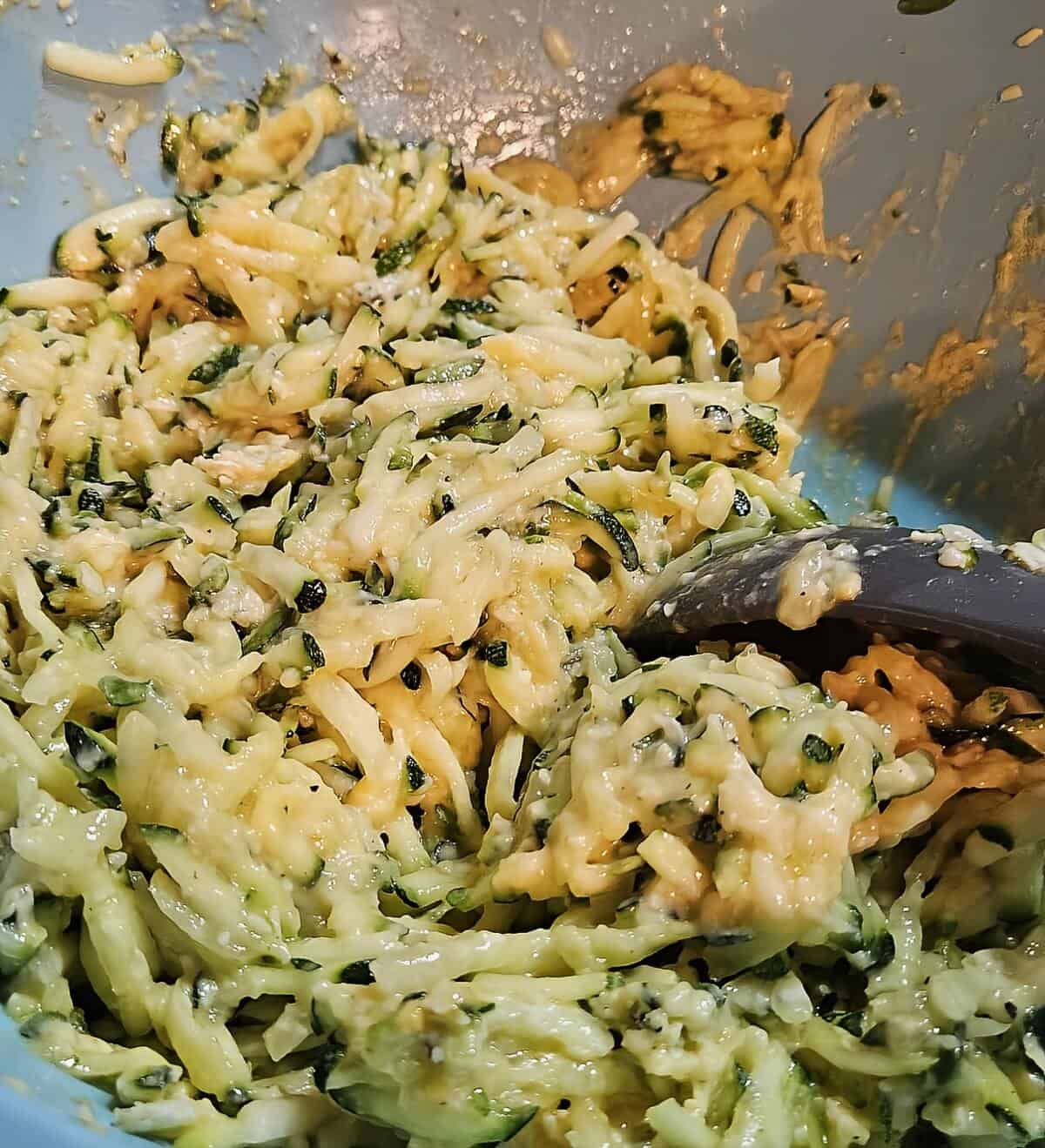 zucchini,, eggs, and parmesan all mixed up in a bowl