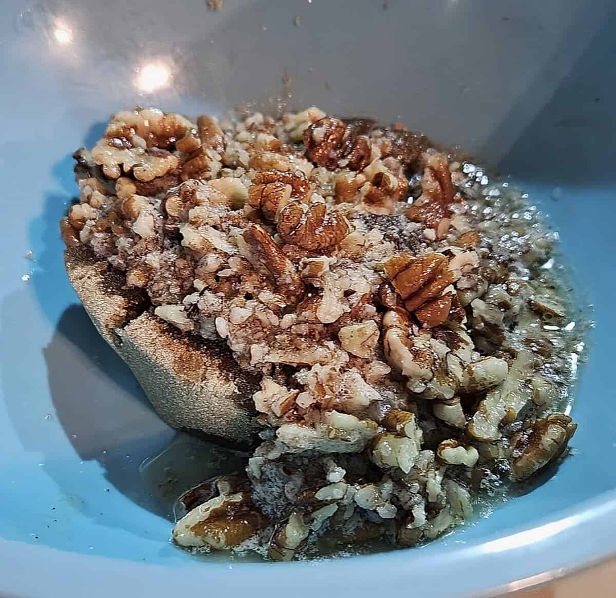 pecans and melted butter in a bowl over brown sugar