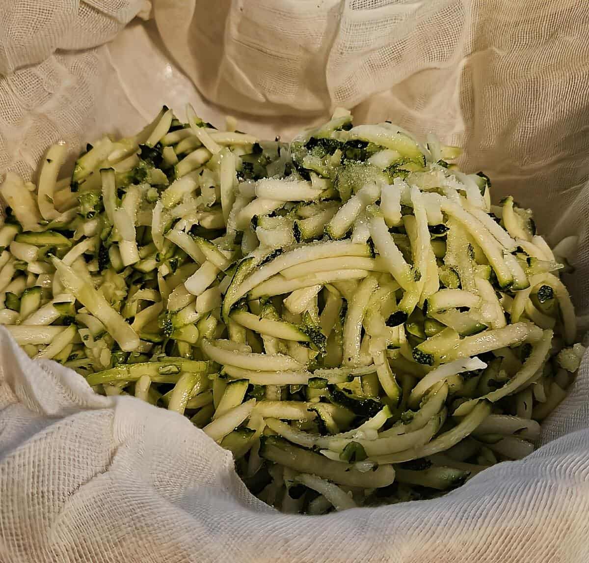 shredded and salted zucchini in cheesecloth, ready to be closed up