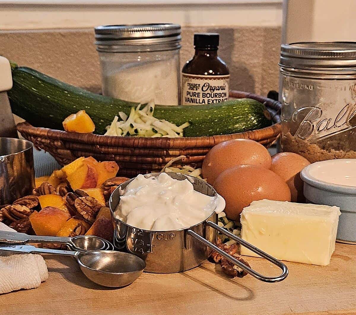 zucchini bread ingredients; zucchini, (shredded and whole), sugar, vanilla extract, brown sugar, eggs, butter, pecans, yogurt, and peaches.