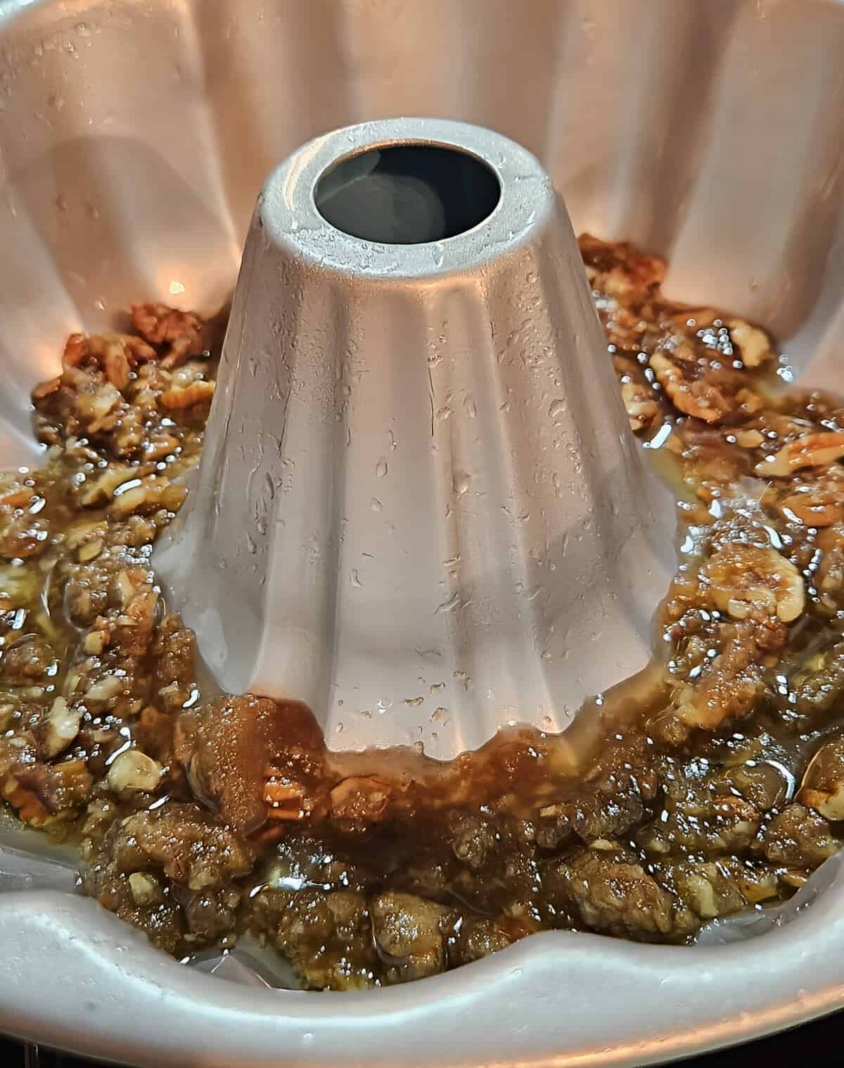 pecan praline mixture coating the bottom of a bundt pan