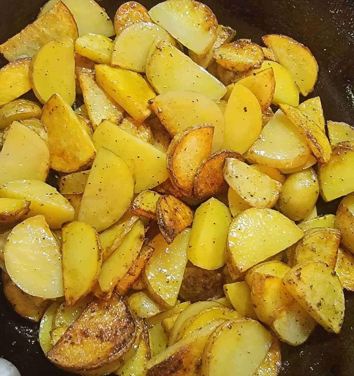 sliced potatoes in skillet browning
