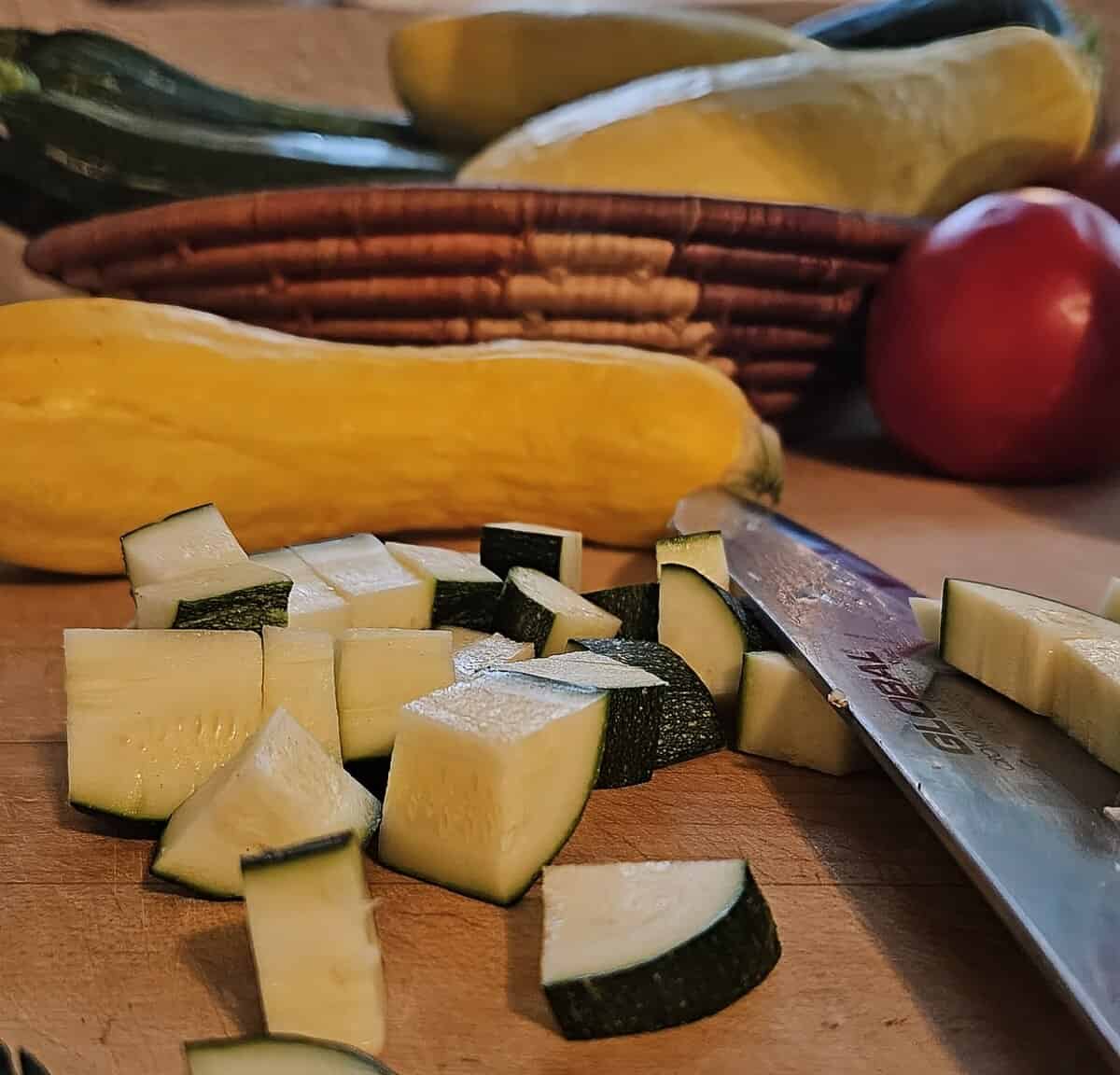 chopped zucchini on a cutting board with a knife