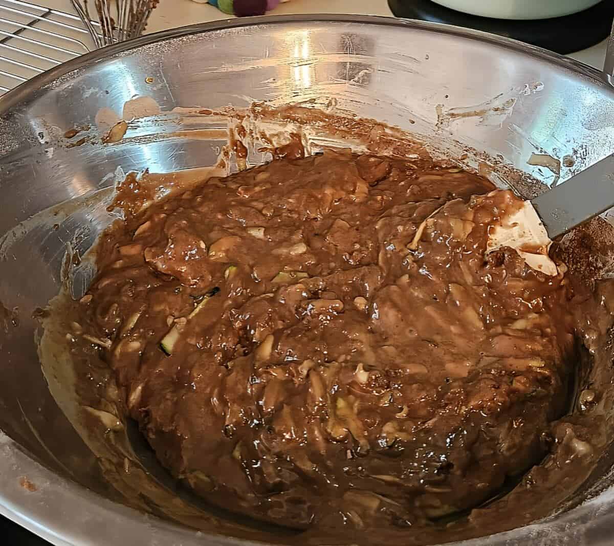 batter for zucchini brownies mixed together with a rubber spatula in a bowl