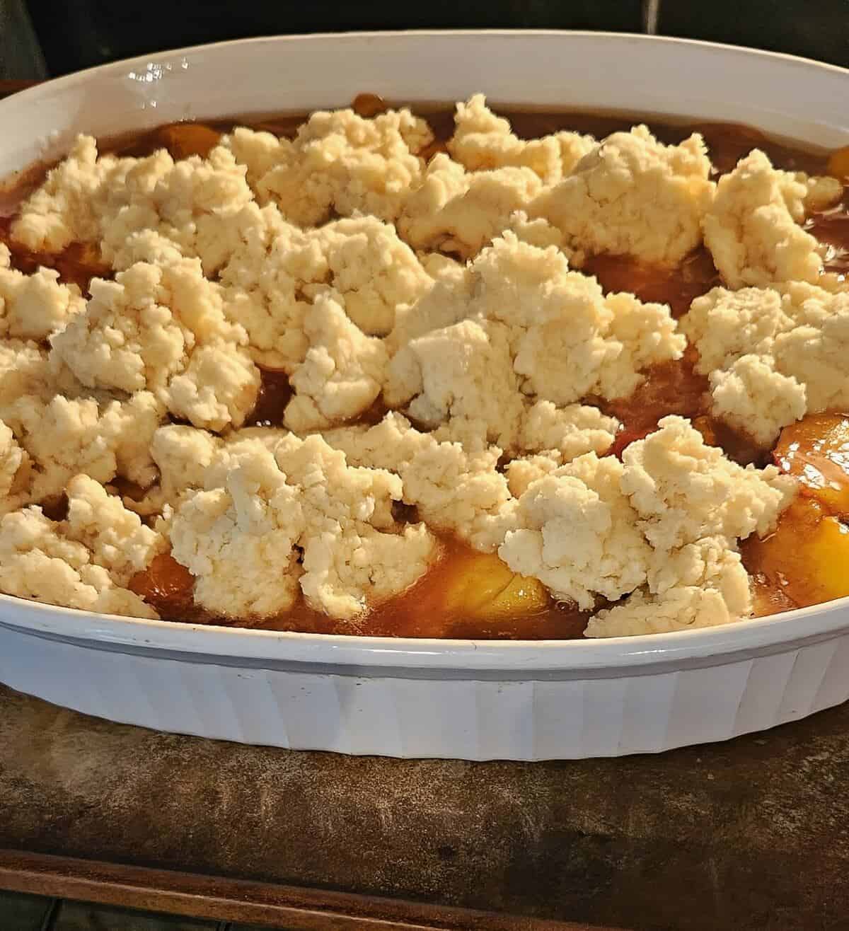unbaked cobbler in pan with sheet pan under it