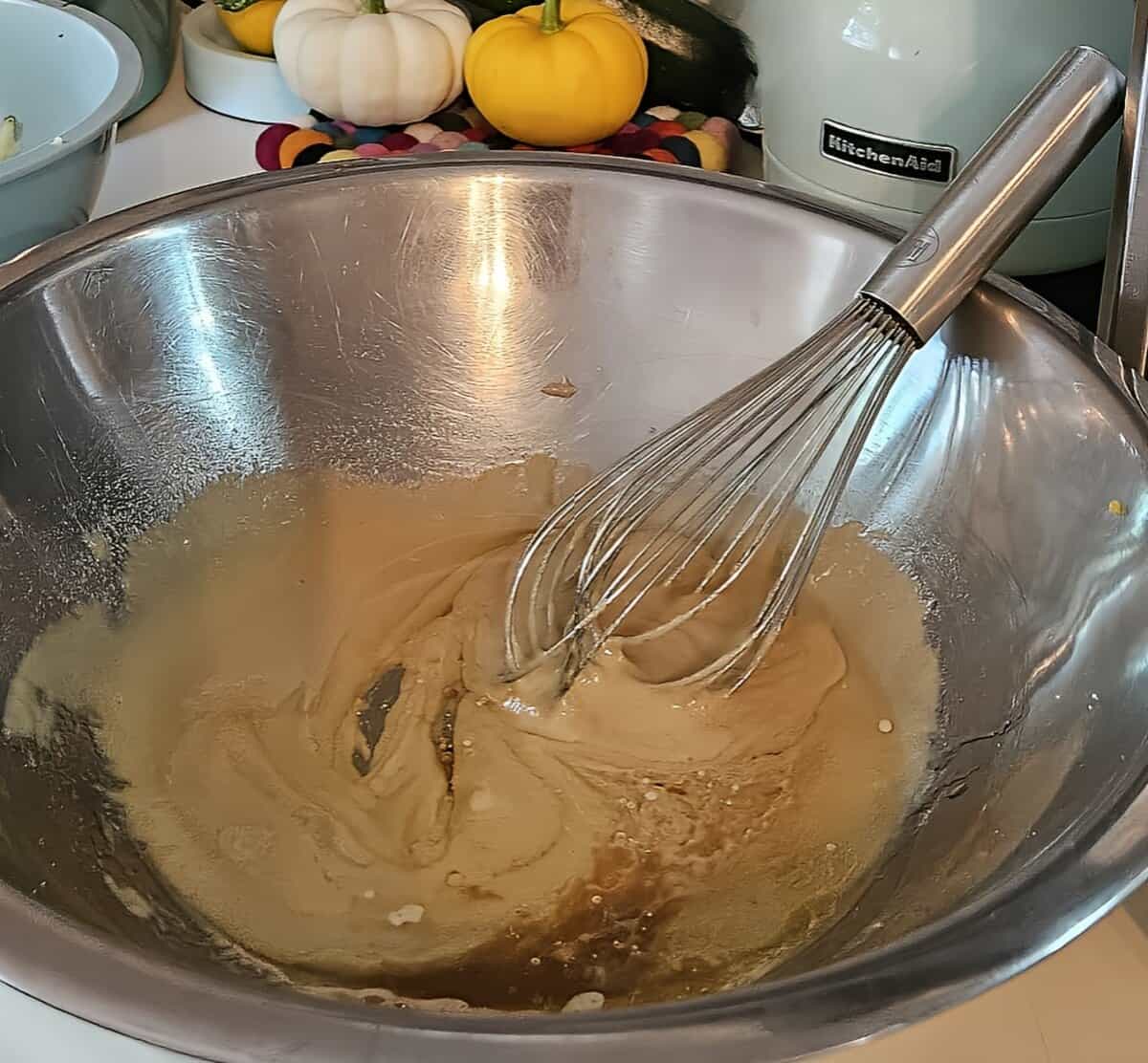 sugar, brown sugar, vanilla paste, and melted butter in a bowl with a wire whip resting in it