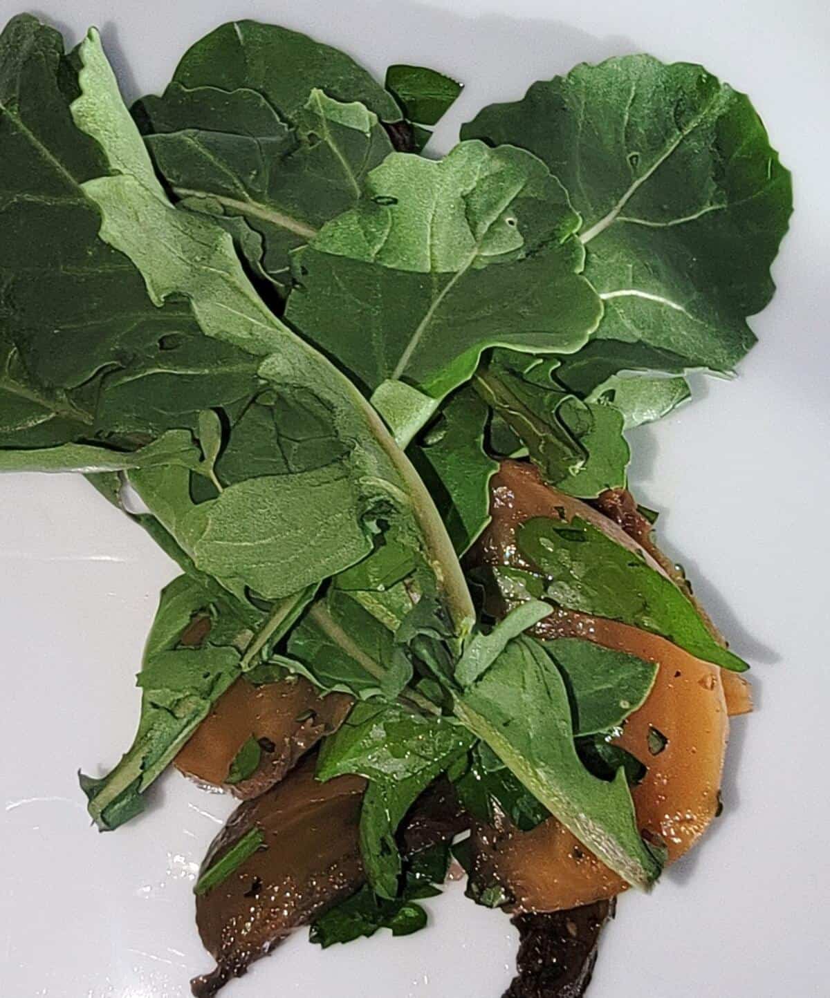 finished beets under a layer of fresh arugula on plate.