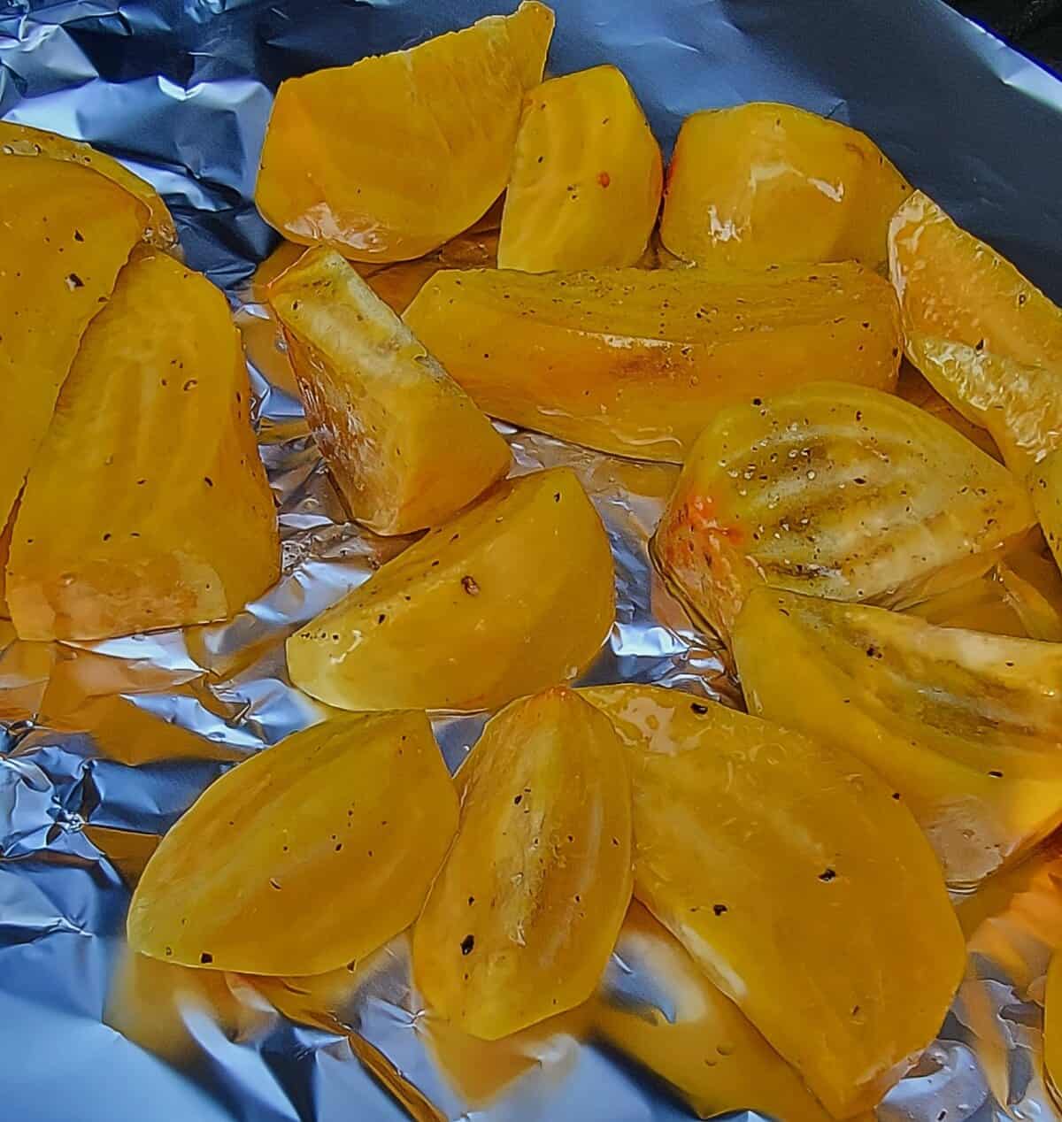seasoned and oiled golden beet pieces, on foil in smoker.
