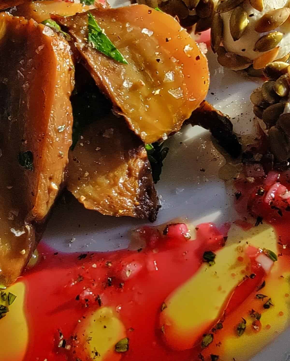 Close up of composed salad showing finished hibiscus vinaigrette on plate