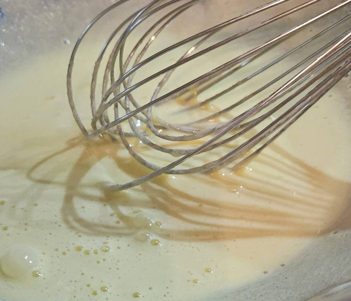 whipping together the cream and yolk mixtures for bourbon sauce