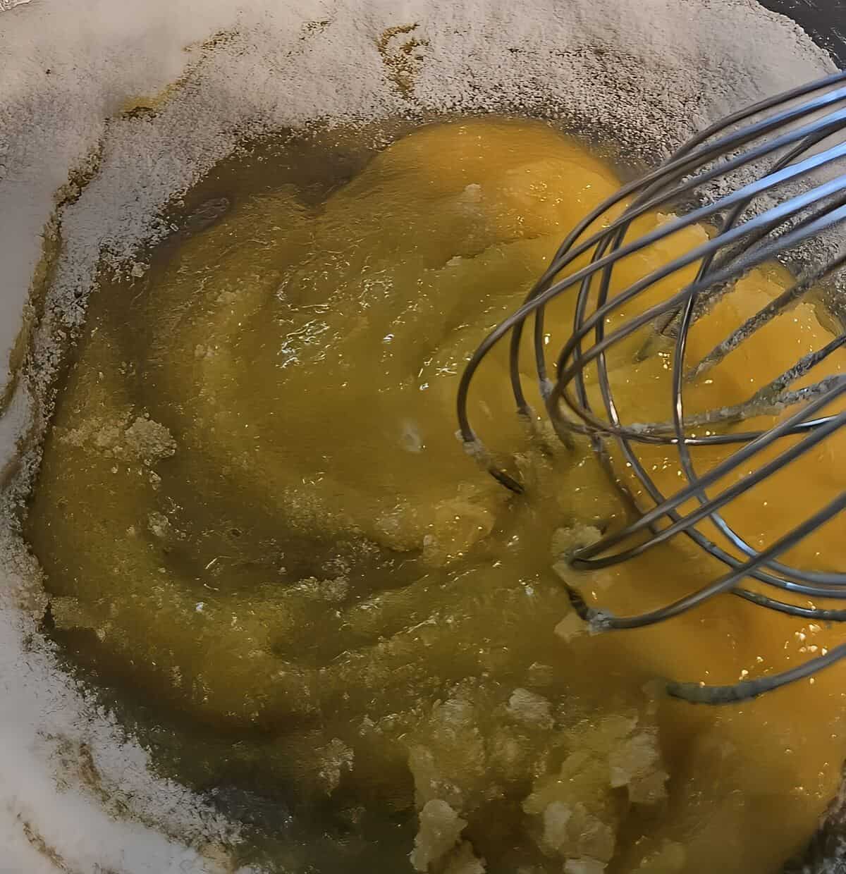 mixing egg yolks with sugar using a wire whip for bourbon sauce