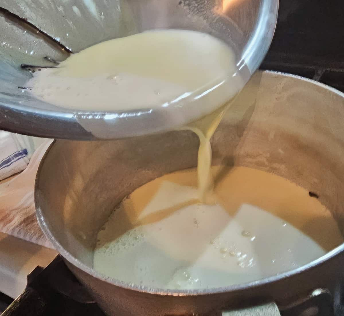 cream being poured from a mixing bowl into a saucepan