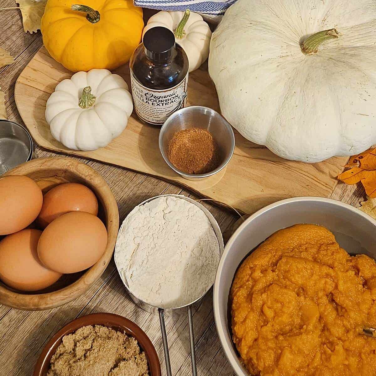 ingredients for pumpkin whoopie pies; vanilla extract, pumpkin pie spice, eggs, flour, pumpkin puree, light brown sugar.