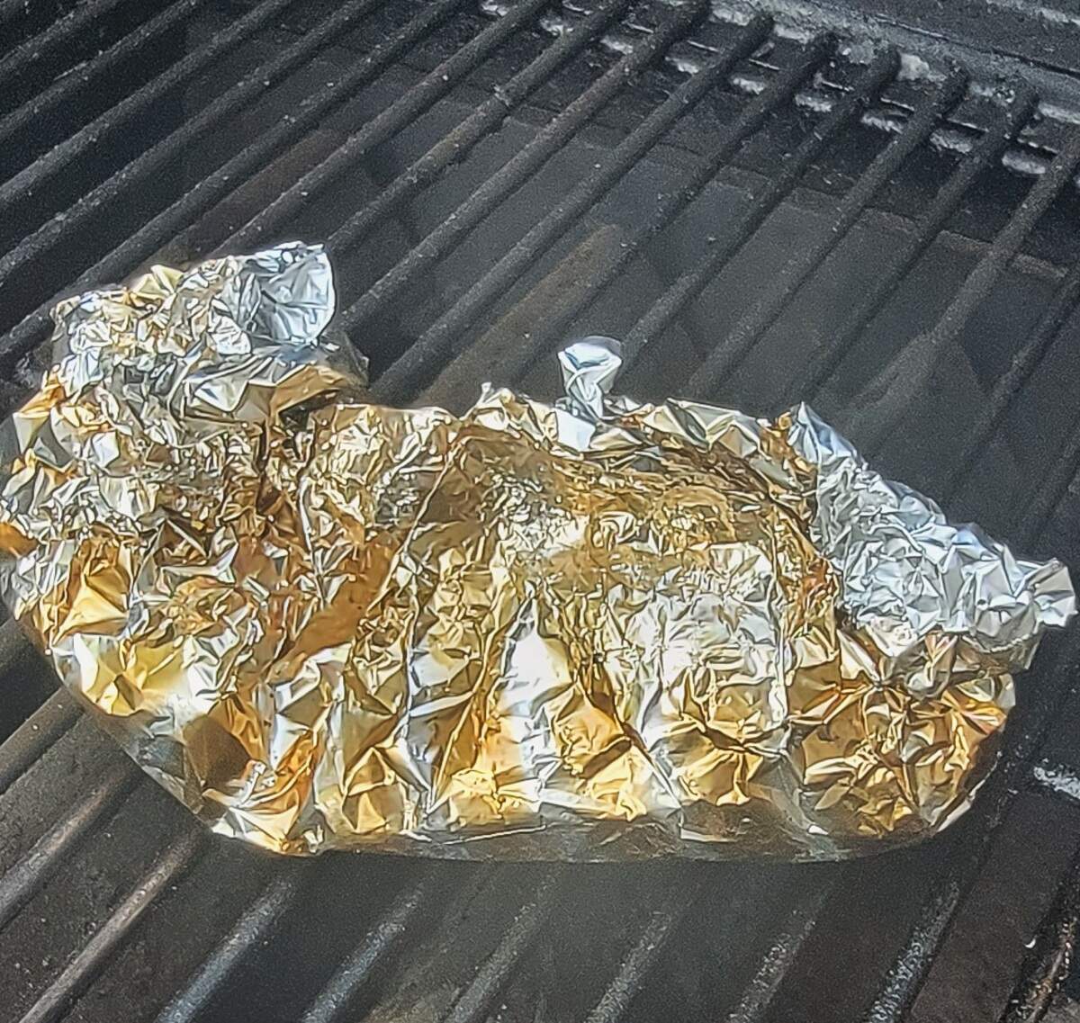 foil packet wrapped up tight containing beets on smoker grate