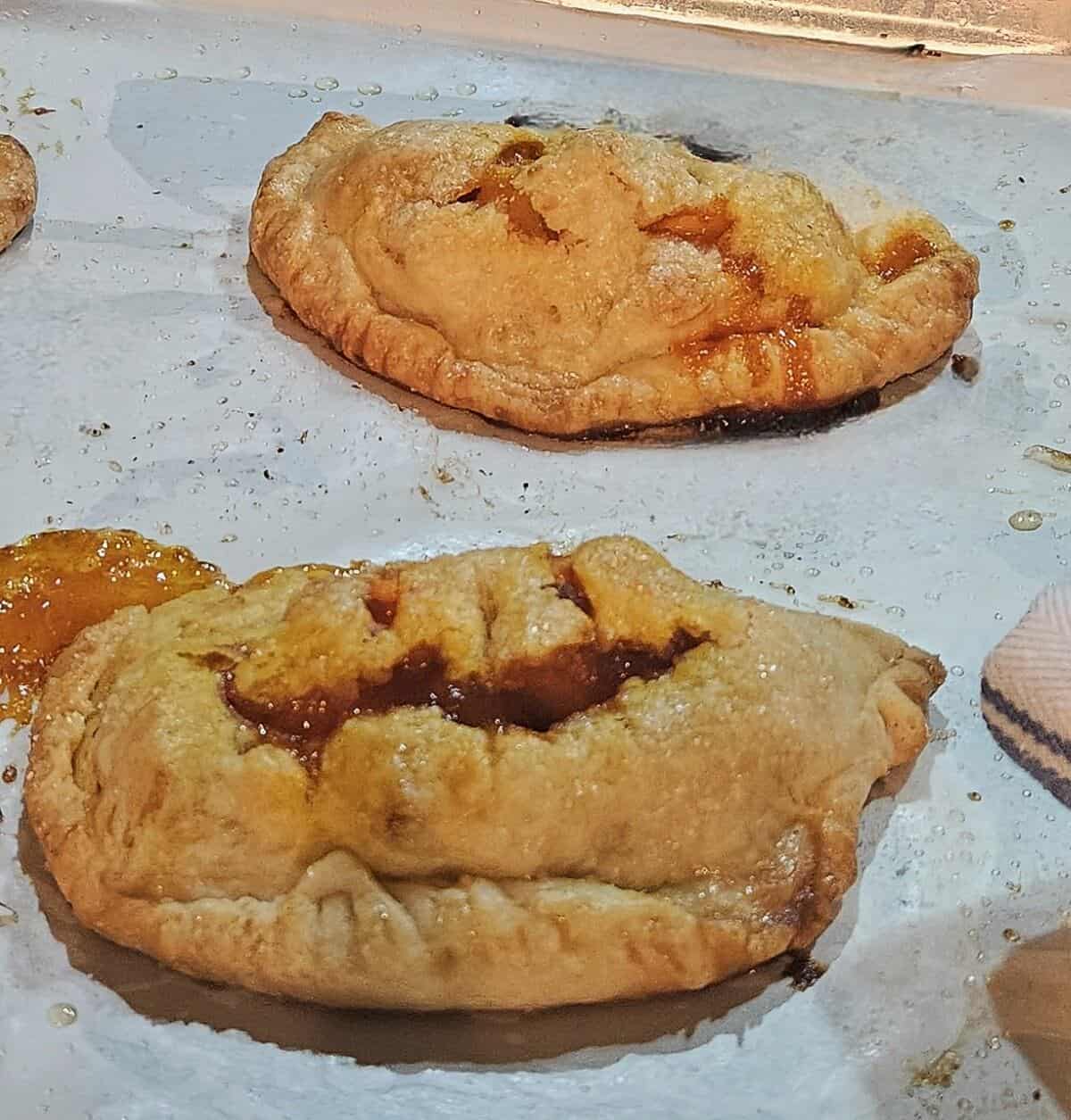 finished caramel apple empanadas on parchment lined sheet pan