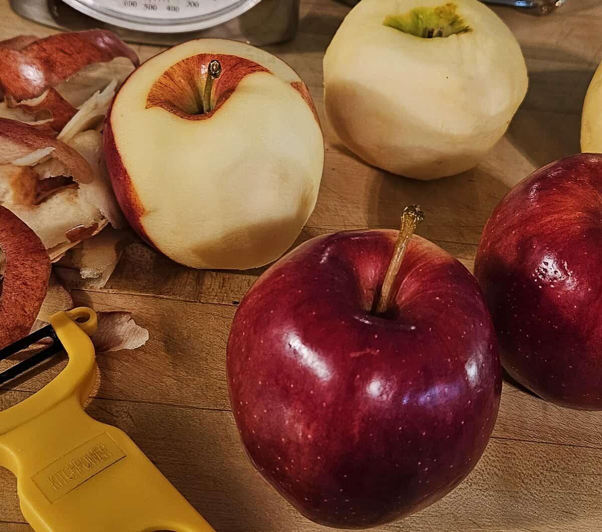 apples, whole, both peeled and un peeled, with peeler and peels