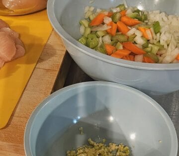 chicken cobbler ingredients chopped. carrots, celery and onion in one bowl, minced garlic in another.