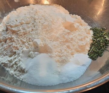 dry ingredients for chicken cobbler biscuit topping; flour, baking soda, chopped fresh rosemary, salt.