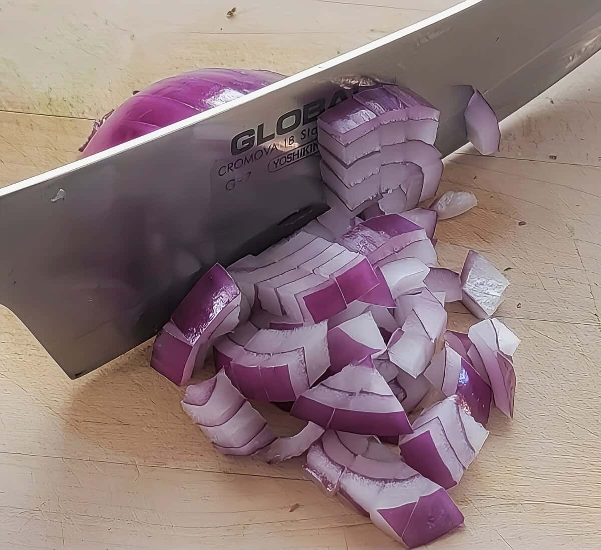 half of a red onion, peeled, sliced once vertically to the root end, and several times horizontally to form uniform cuts, and then with a knife cutting through to form small dice.