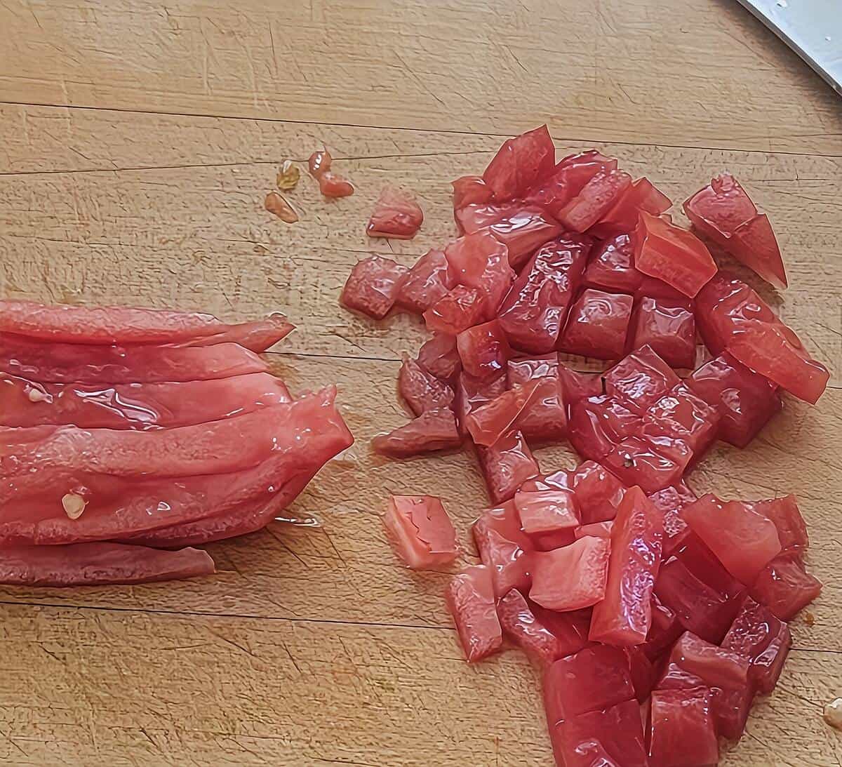 filet of tomato cut into slices, and then into small dice on a cutting board