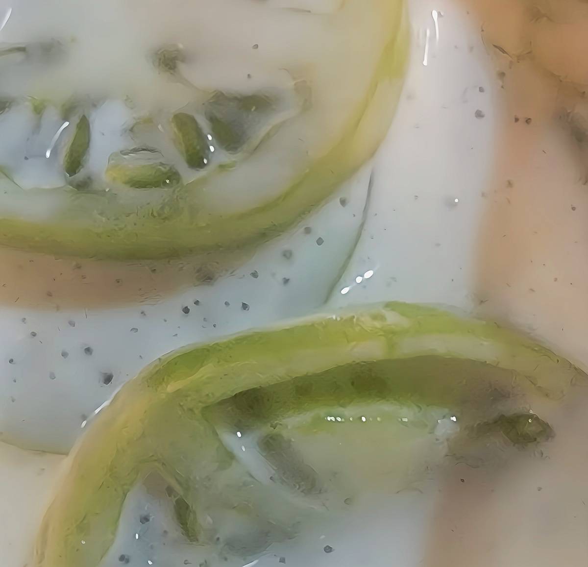 sliced green tomatoes submerged in buttermilk