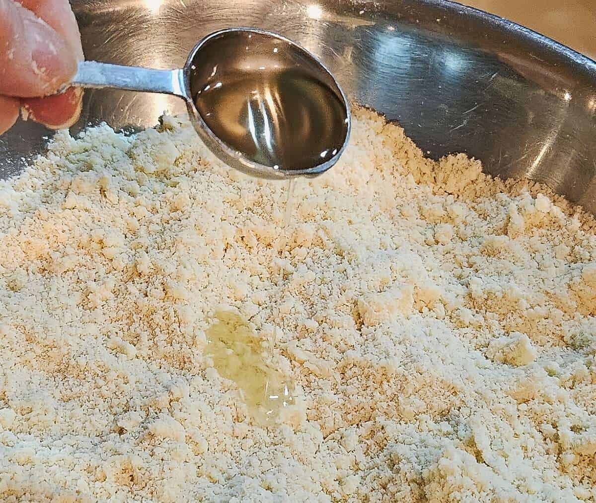 flour and butter mixture with a tablespoon of oil being drizzled into it
