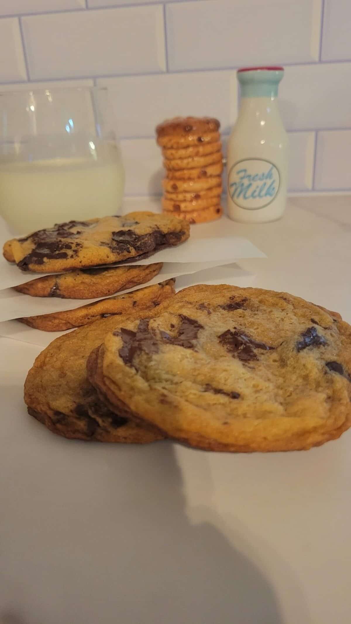 finished dark chocolate chunk cookies shown with cold glass of milk