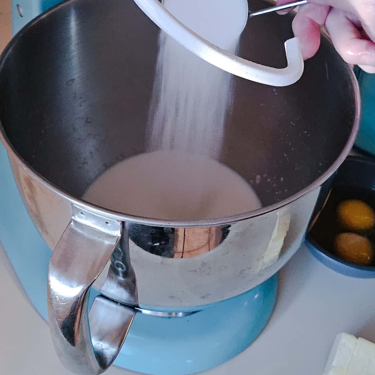 adding sugar to stand mixer bowl