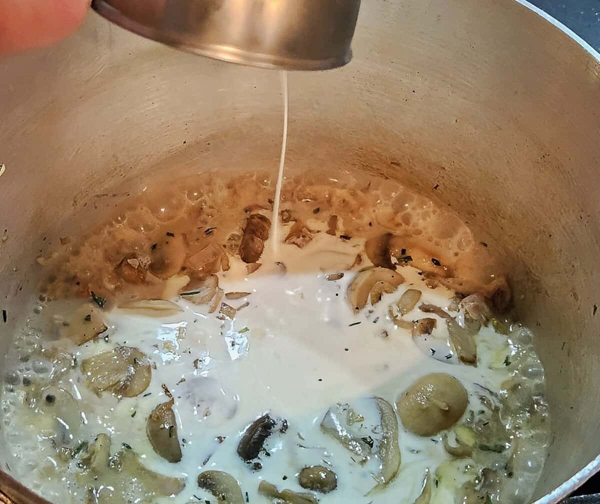 mushroom soup bubbling, cream and milk being poured into the pot