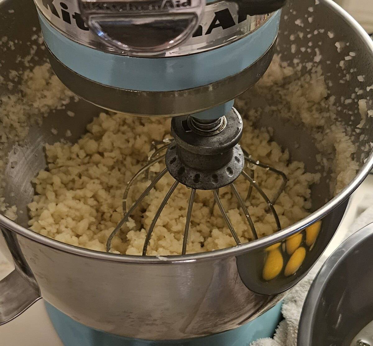 pate choux dough being scattered around the edges of the mixer bowl, cooling