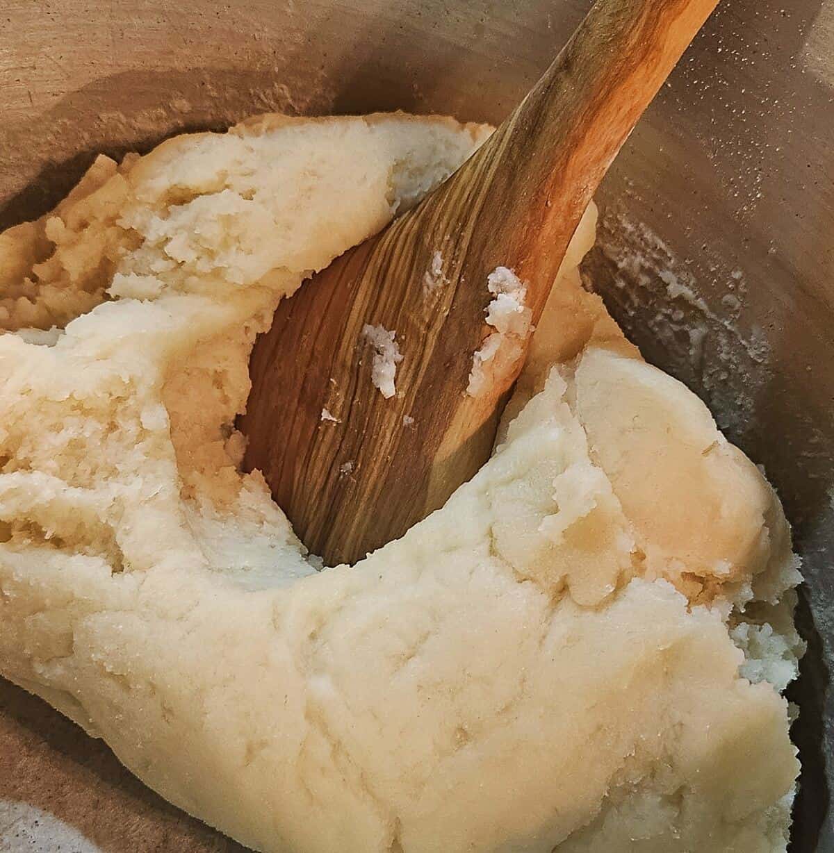 pate choux dough beginning to reach the right consistency, just starting to pull away from the pan and losing moisture.