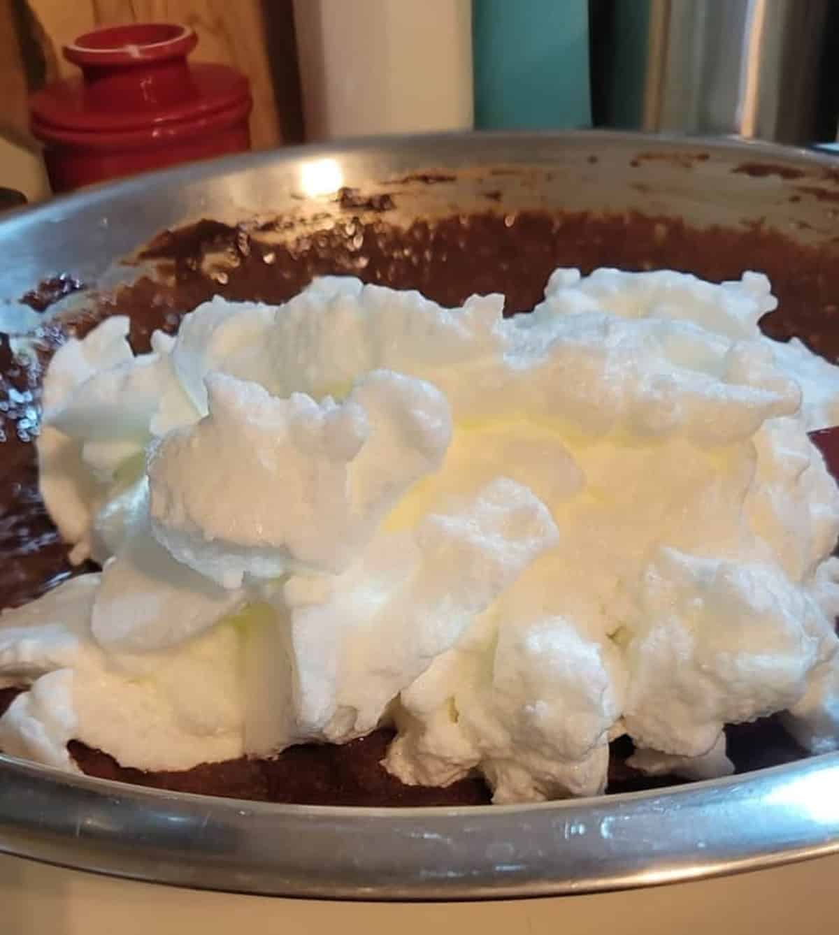 whipped egg whites floating on chocolate mixture in mixing bowl
flourless chocolate torte