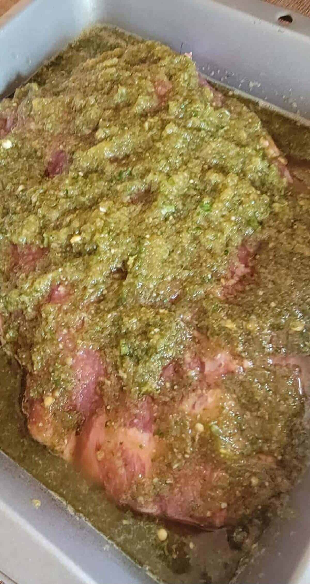 flank steak covered with marinade in pan