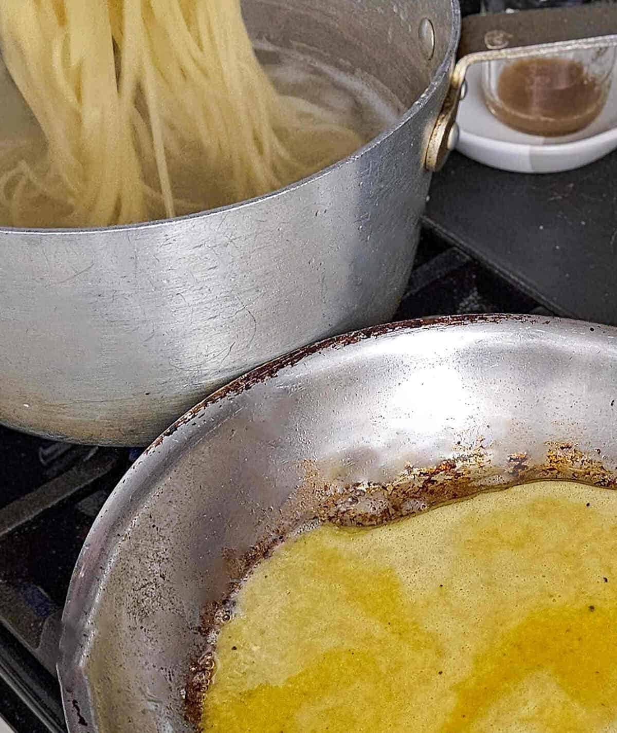 moving the cooked pasta from the boiling water to the pan with the sauce for the pasta carbonara with mushrooms