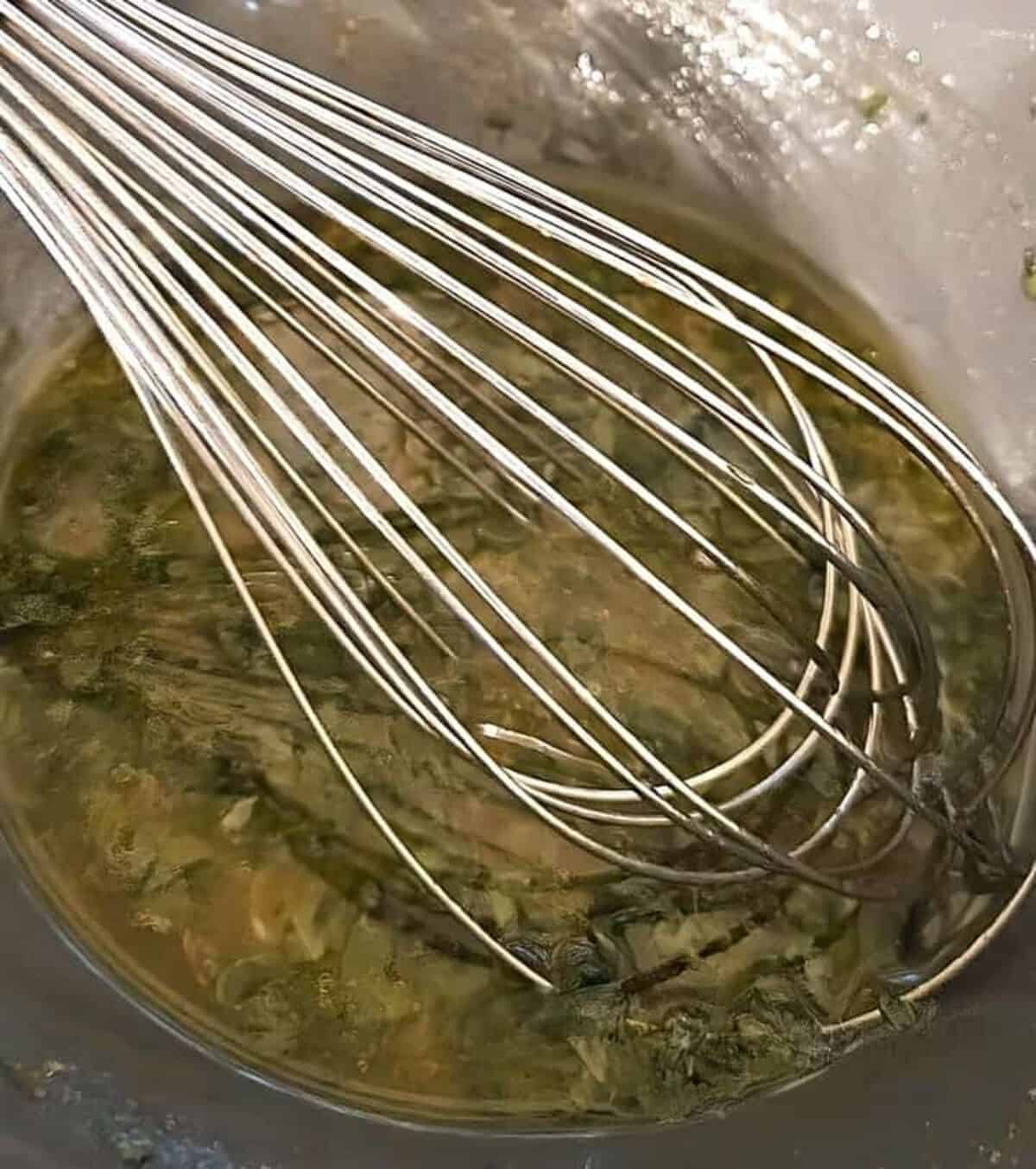 marinade in a bowl being stirred together with a whisk.