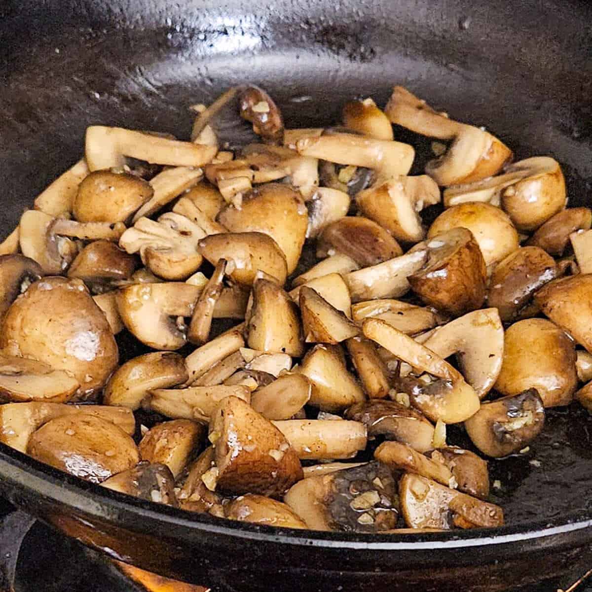 mushrooms cooking in a pan with garlic for the pasta carbonara with mushrooms