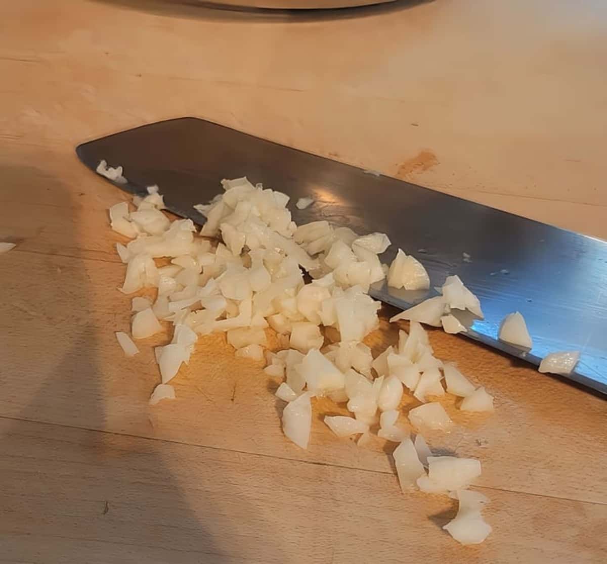 minced garlic on cutting board with knife