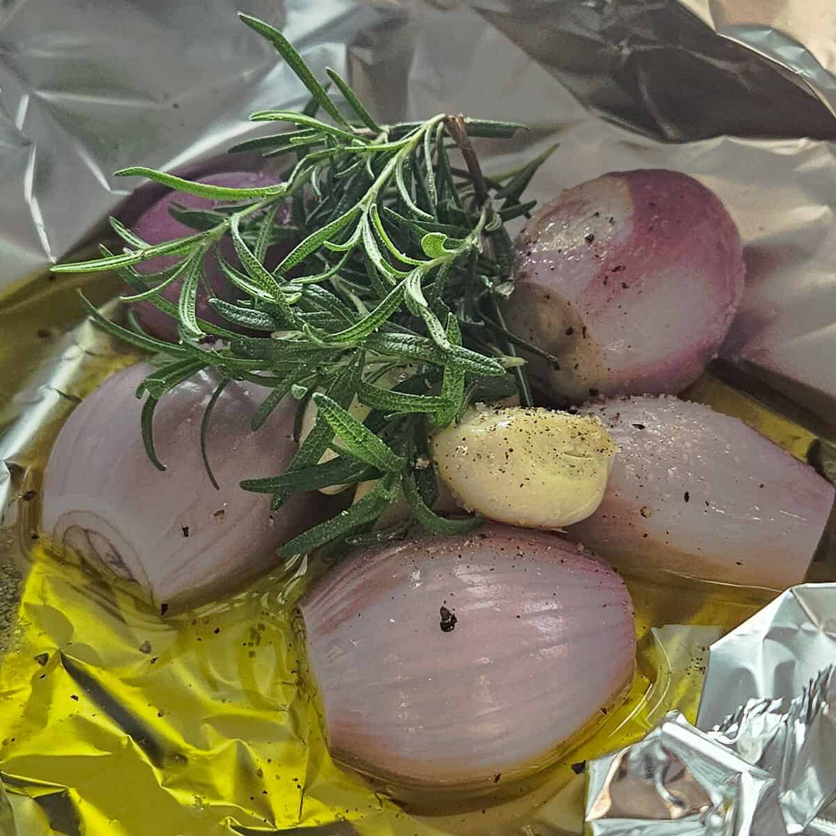 the shallots, garlic, and rosemary in foil with olive oil and salt and pepper ready to place in the oven, for the potato and shallot soup with crispy prosciutto