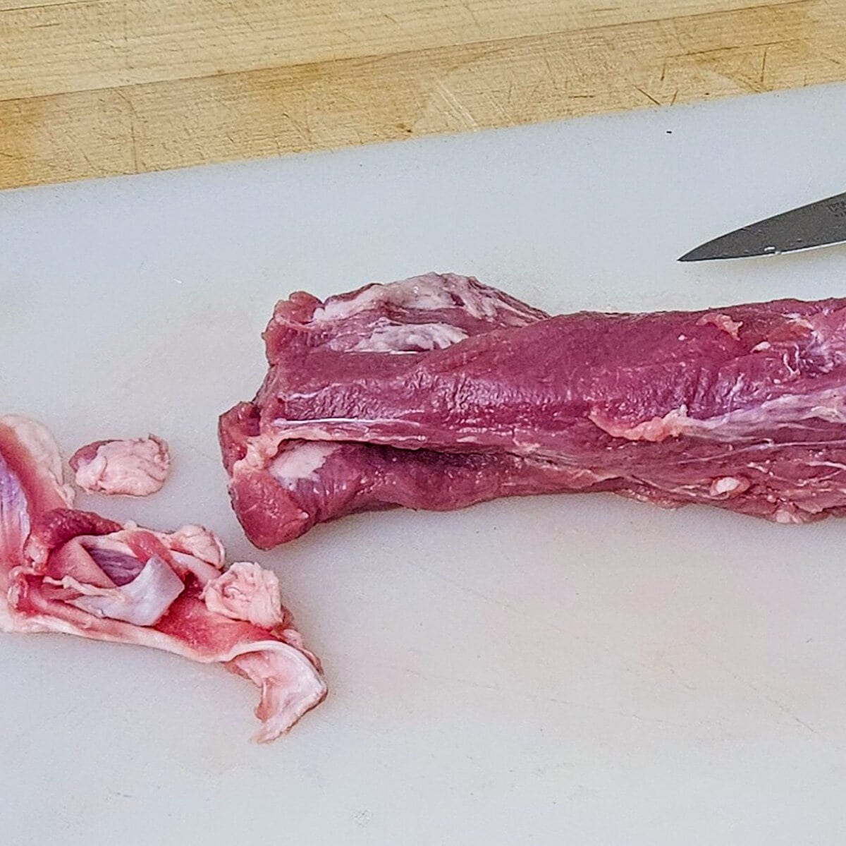 the pork tenderloin with the silver skin removed on a cutting board for the cast iron seared pork tenderloin with tangerine ginger sauce