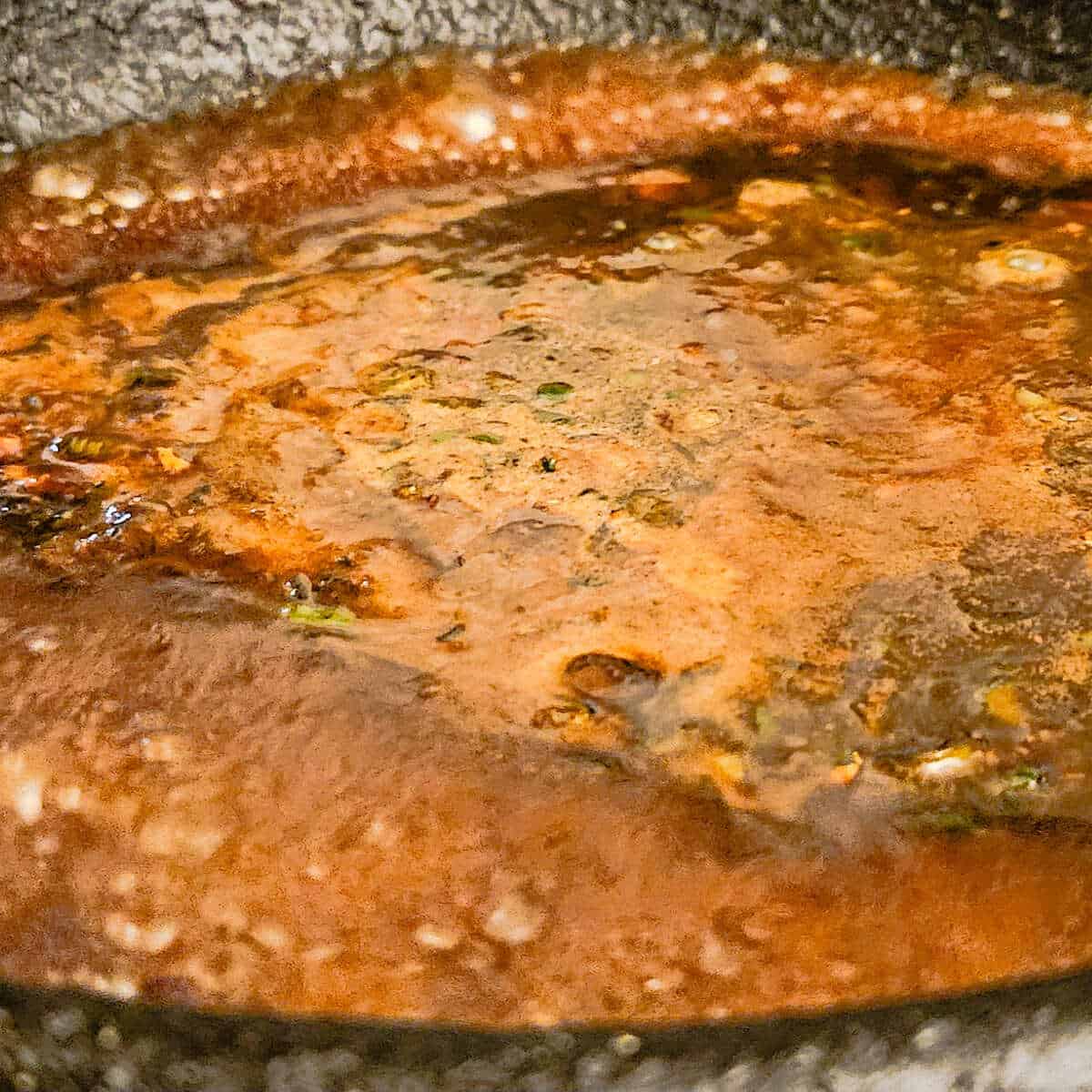 the sauce in a pan reducing for the cast iron seared pork tenderloin with tangerine ginger sauce