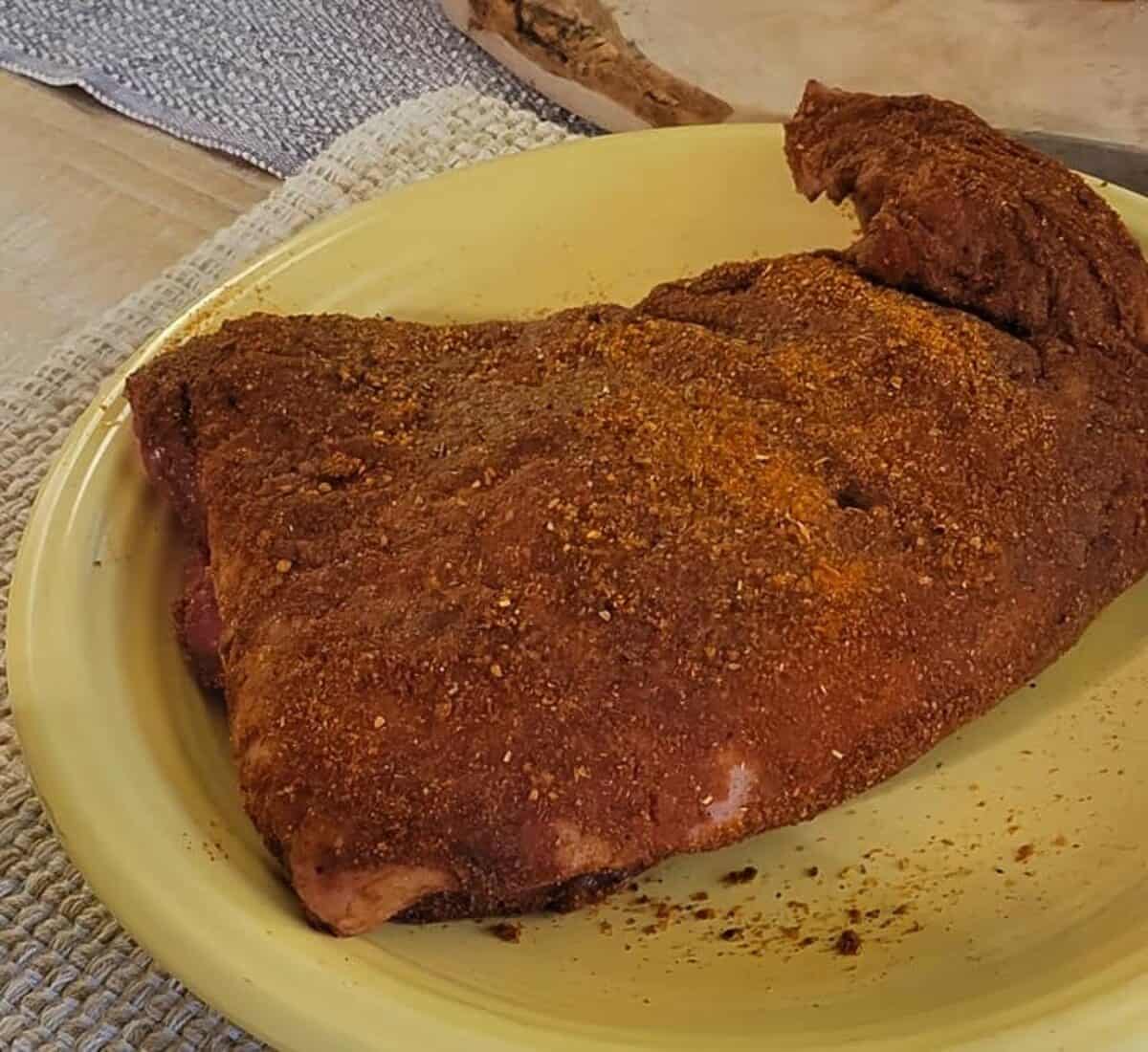 tri tip of beef. raw, rubbed with spices.