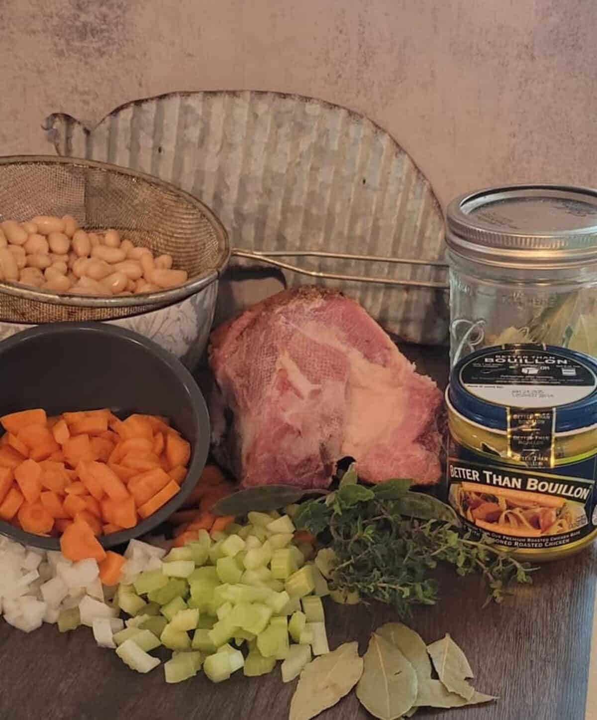 jar of bay leaves, chicken bouillon, fresh herbs, bay leaves, chopped celery, onion, and carrots, strained white beans, ham