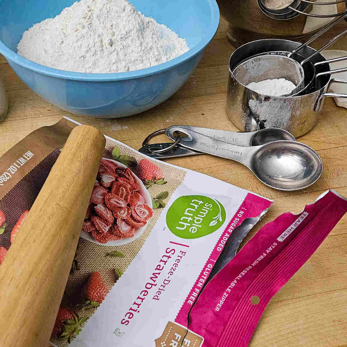 smashing the freeze dried strawberries in the bag with a rolling pin for the best strawberry shortbread sandwich cookie recipe