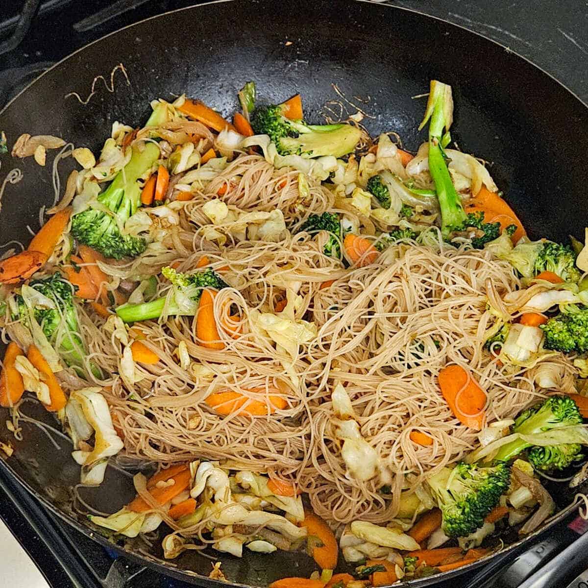 easy Asian vegetable stir fry rice noodles in the wok seasoned with soy sauce ready to be served