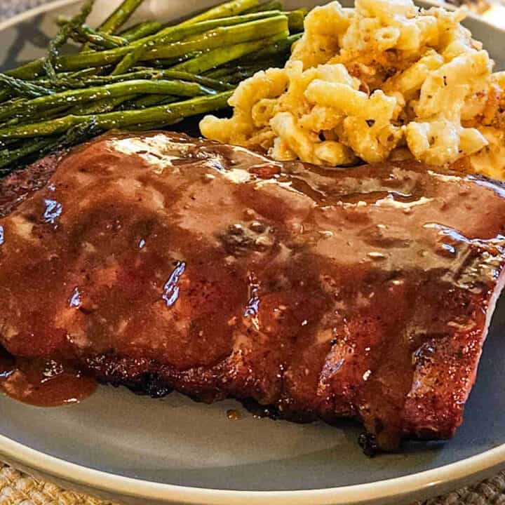 baby back pork ribs on a plate with mac and cheese and a asparagus with western North Carolina BBQ sauce