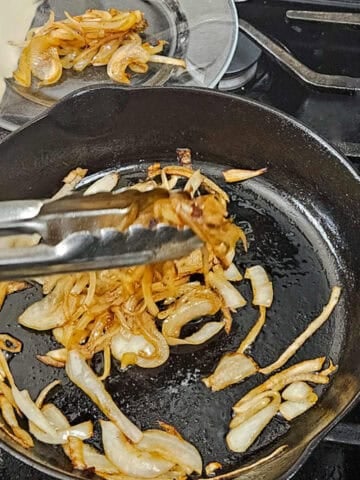 Removing the browned onions from the pan for the white cheddar and bacon zucchini bake.