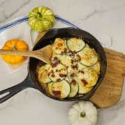 The white cheddar and bacon zucchini bake ready to eat with a wooden serving spoon.